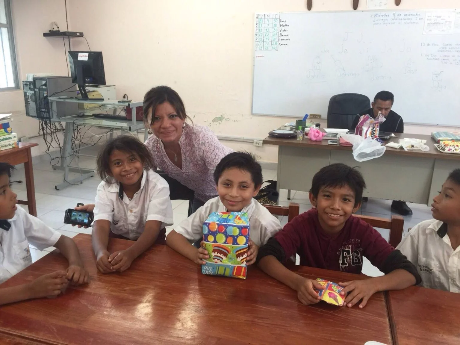 La Maestra Yoli trabajando con un niño en el aula